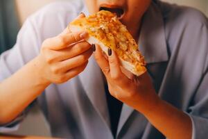 recortado imagen de mujer participación Pizza rebanada a restaurante foto