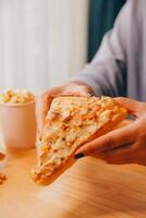 Cropped image of woman holding pizza slice at restaurant photo