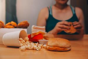 fast food, people and unhealthy eating concept - close up of woman hands holding hamburger or cheeseburger photo