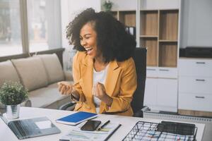 mujer de negocios asiática que usa una computadora portátil y trabaja en la oficina con un documento de calculadora en el escritorio, planificando el análisis del informe financiero, la inversión del plan de negocios, el concepto de análisis financiero. foto