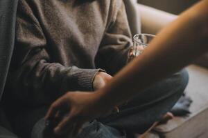 Upset woman frustrated by problem with work or relationships, sitting on couch, embracing knees, covered face in hand, feeling despair and anxiety, loneliness, having psychological trouble photo