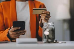 Woman is doing online purchases. Girl is doing shopping using phone and credit card at home. photo