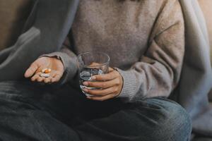 Upset woman frustrated by problem with work or relationships, sitting on couch, embracing knees, covered face in hand, feeling despair and anxiety, loneliness, having psychological trouble photo