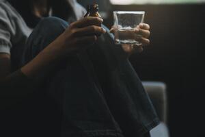 Upset woman frustrated by problem with work or relationships, sitting on couch, embracing knees, covered face in hand, feeling despair and anxiety, loneliness, having psychological trouble photo