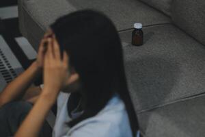 Upset woman frustrated by problem with work or relationships, sitting on couch, embracing knees, covered face in hand, feeling despair and anxiety, loneliness, having psychological trouble photo