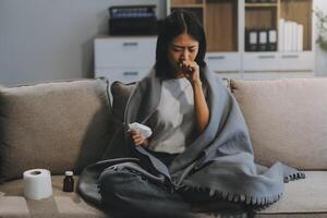 Upset woman frustrated by problem with work or relationships, sitting on couch, embracing knees, covered face in hand, feeling despair and anxiety, loneliness, having psychological trouble photo