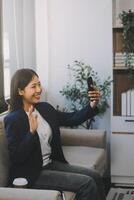 Happy pretty blonde young woman reading text message on smartphone, receiving good news, looking at screen, smiling. Mobile phone user satisfied with online app, virtual service work, using cellphone photo