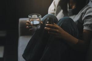 Upset woman frustrated by problem with work or relationships, sitting on couch, embracing knees, covered face in hand, feeling despair and anxiety, loneliness, having psychological trouble photo