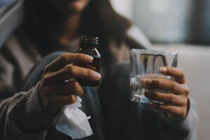 trastornado mujer frustrado por problema con trabajo o relaciones, sentado en sofá, abrazando rodillas, cubierto cara en mano, sensación desesperación y ansiedad, soledad, teniendo psicológico problema foto