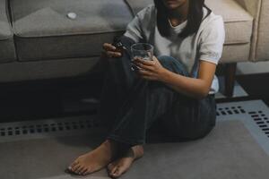 Upset woman frustrated by problem with work or relationships, sitting on couch, embracing knees, covered face in hand, feeling despair and anxiety, loneliness, having psychological trouble photo