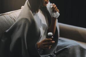 Upset woman frustrated by problem with work or relationships, sitting on couch, embracing knees, covered face in hand, feeling despair and anxiety, loneliness, having psychological trouble photo