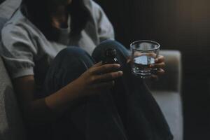 Upset woman frustrated by problem with work or relationships, sitting on couch, embracing knees, covered face in hand, feeling despair and anxiety, loneliness, having psychological trouble photo