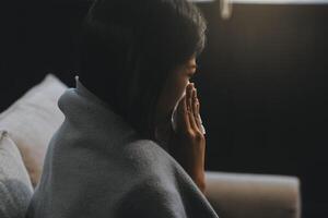 Upset woman frustrated by problem with work or relationships, sitting on couch, embracing knees, covered face in hand, feeling despair and anxiety, loneliness, having psychological trouble photo