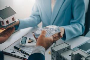Real estate agent talked about the terms of the home purchase agreement and asked the customer to sign the documents to make the contract legally, Home sales and home insurance concept. photo