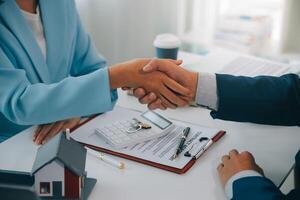 Real estate agent talked about the terms of the home purchase agreement and asked the customer to sign the documents to make the contract legally, Home sales and home insurance concept. photo