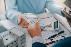 Real estate agent talked about the terms of the home purchase agreement and asked the customer to sign the documents to make the contract legally, Home sales and home insurance concept. photo