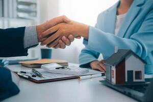 Real estate agent talked about the terms of the home purchase agreement and asked the customer to sign the documents to make the contract legally, Home sales and home insurance concept. photo