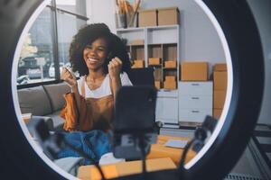 Moda blogger concepto, joven asiático mujer de venta ropa en streaming.startup pequeño negocio pequeño, utilizando teléfono inteligente o tableta tomando recibir y comprobación en oficina foto