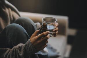 Upset woman frustrated by problem with work or relationships, sitting on couch, embracing knees, covered face in hand, feeling despair and anxiety, loneliness, having psychological trouble photo