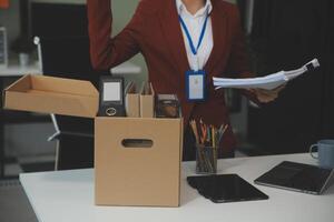 mujer de negocios embalaje su cosas para moverse foto