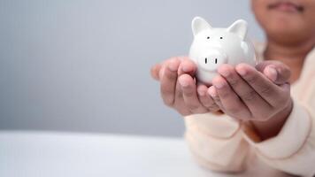 A boy holding piggy bank. Learning financial responsibility and projecting savings. savings concept. investment concept. photo