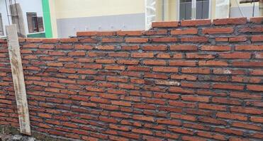 Portrait of the process of building a wall with bricks that look unfinished photo