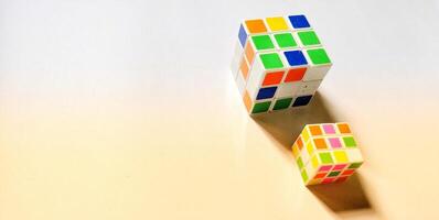 CENTRAL JAVA, INDONESIA - April 25, 2024. Two Rubik's Cubes on a white background morning sunlight concept, illustrative editorial. photo