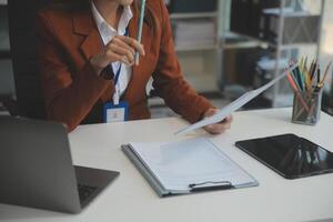 mujer sentado a escritorio y trabajando a computadora manos cerca arriba foto