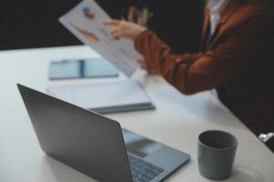 mujer sentado a escritorio y trabajando a computadora manos cerca arriba foto