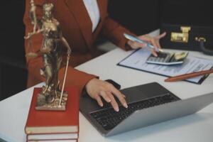 americano mujer abogado o mujer de negocios africano trabajando con computadora portátil, buscando, analizando datos, leyendo contrato documentos trabajo con ley libros martillo de justicia consultante abogado concepto. foto