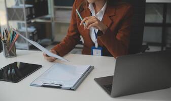 mujer sentado a escritorio y trabajando a computadora manos cerca arriba foto