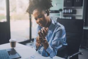 Asian woman working hard in the office having aches and pains in her torso and waist photo