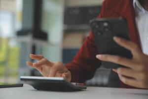 mujer de negocios asiática con traje formal en la oficina feliz y alegre durante el uso del teléfono inteligente y el trabajo foto