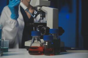 profesional químico mujer laboratorio utilizando científico microscopio para Ciencias investigación, química científico con microbiología medicos equipo tecnología a trabajando con medicina biología experimentar foto