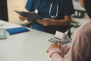 médico y paciente discutiendo algo mientras están sentados en la mesa. concepto de medicina y atención de la salud. medico y paciente foto