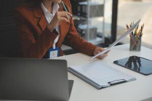 mujer sentado a escritorio y trabajando a computadora manos cerca arriba foto