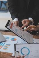 Co working conference, Business team meeting present, investor colleagues discussing new plan financial graph data on office table with laptop and digital tablet, Finance, accounting, investment. photo