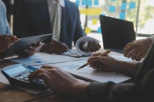 conferencia de trabajo conjunto, reunión del equipo de negocios presente, colegas inversores que discuten los datos del gráfico financiero del nuevo plan en la mesa de la oficina con computadora portátil y tableta digital, finanzas, contabilidad, inversión. foto