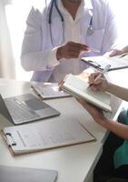 Medical Team Meeting Around Table In Modern Hospital photo