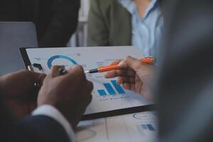 conferencia de trabajo conjunto, reunión del equipo de negocios presente, colegas inversores que discuten los datos del gráfico financiero del nuevo plan en la mesa de la oficina con computadora portátil y tableta digital, finanzas, contabilidad, inversión. foto