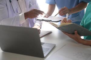 Medical Team Meeting Around Table In Modern Hospital photo