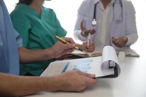 médico equipo reunión alrededor mesa en moderno hospital foto