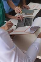 Medical Team Meeting Around Table In Modern Hospital photo