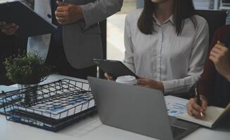 Financial analysts analyze business financial reports on a digital tablet planning investment project during a discussion at a meeting of corporate showing the results of their successful teamwork. photo