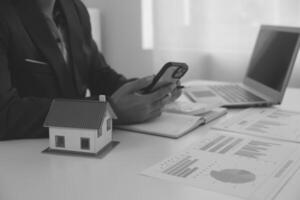 Businessmen holding pens, signing home titles with insurance, care about real estate services and the idea of real estate agents offering interest in installments to their customers. photo