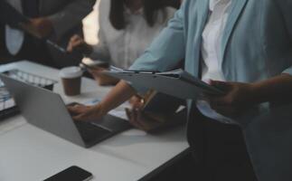 Financial analysts analyze business financial reports on a digital tablet planning investment project during a discussion at a meeting of corporate showing the results of their successful teamwork. photo