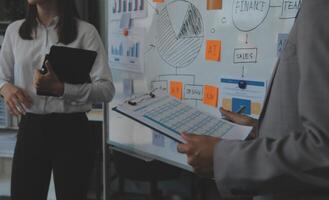 Financial analysts analyze business financial reports on a digital tablet planning investment project during a discussion at a meeting of corporate showing the results of their successful teamwork. photo