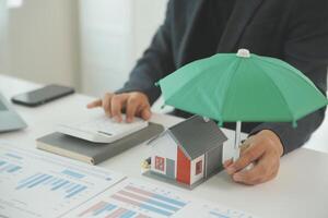 Businessmen holding pens, signing home titles with insurance, care about real estate services and the idea of real estate agents offering interest in installments to their customers. photo