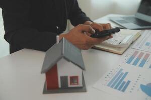 Businessmen holding pens, signing home titles with insurance, care about real estate services and the idea of real estate agents offering interest in installments to their customers. photo