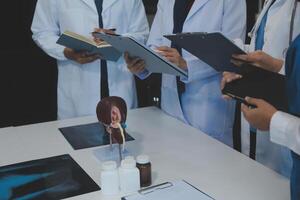 médico, reunión y ordenador portátil para equipo en oficina en discusión, lluvia de ideas y planificación. doctor, enfermero y computadora en escritorio, trabajo en equipo o taller para modelo interno Organo. foto